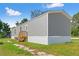 Side view of a gray home with green lawn on a beautiful sunny day at 16070 La Bella St, Brooksville, FL 34604