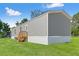 Side view of a gray home with green lawn on a beautiful sunny day at 16070 La Bella St, Brooksville, FL 34604