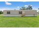 Charming gray home with green lawn and black shutters on a sunny day at 16070 La Bella St, Brooksville, FL 34604