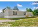 Gray home with green lawn and mature trees in a peaceful neighborhood at 16070 La Bella St, Brooksville, FL 34604
