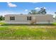 Charming gray home with green lawn and black shutters on a sunny day at 16070 La Bella St, Brooksville, FL 34604
