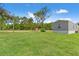 Large grassy yard with plenty of space and a gray house in the background at 16070 La Bella St, Brooksville, FL 34604