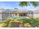 Spacious backyard with a screened pool area and a white picket fence at 1611 Cresson Ridge Ln, Brandon, FL 33510
