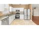Well-lit kitchen with tile floors, stainless steel appliances, granite countertops and white cabinets at 1611 Cresson Ridge Ln, Brandon, FL 33510