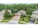 Aerial view of a well-maintained home with a three-car garage, driveway, and lush landscaping at 19312 Sunset Bay Dr, Land O Lakes, FL 34638