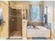 Bright bathroom featuring a walk-in shower and soaking tub with tile surround and a window view at 19312 Sunset Bay Dr, Land O Lakes, FL 34638