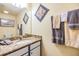 This bathroom features a vanity with granite countertop and decorative wall hangings at 19312 Sunset Bay Dr, Land O Lakes, FL 34638