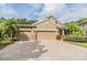 Charming one-story home featuring a three-car garage, brick paved driveway, and beautiful landscaping at 19312 Sunset Bay Dr, Land O Lakes, FL 34638
