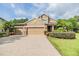 Home with a three-car garage, brick-paved driveway, and well-maintained landscaping at 19312 Sunset Bay Dr, Land O Lakes, FL 34638