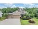 Beautiful home with a well-manicured lawn, a three-car garage, and lush landscaping at 19312 Sunset Bay Dr, Land O Lakes, FL 34638