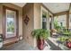 Inviting covered front porch with tile flooring, a decorative door, and outdoor seating area at 19312 Sunset Bay Dr, Land O Lakes, FL 34638