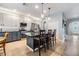 Bright kitchen featuring stainless appliances, a tile backsplash, white and gray cabinets, tile floors, and an island with barstool seating at 19312 Sunset Bay Dr, Land O Lakes, FL 34638