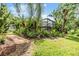 Professionally landscaped backyard with vibrant flowers, lush greenery, and a screened-in patio at 19312 Sunset Bay Dr, Land O Lakes, FL 34638