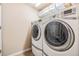 Bright laundry room with front loading washer and dryer and wire shelving at 19312 Sunset Bay Dr, Land O Lakes, FL 34638