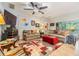Spacious living room featuring tile flooring, a large fan, neutral colors, and a comfortable seating area at 19312 Sunset Bay Dr, Land O Lakes, FL 34638