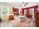 The main bedroom is bright with two large windows, wood floors, ceiling fan, and decorative artwork at 19312 Sunset Bay Dr, Land O Lakes, FL 34638