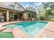 Inviting in-ground pool with spa, screened in enclosure, and covered patio area at 19312 Sunset Bay Dr, Land O Lakes, FL 34638