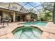 Screened in pool area with an attached spa and covered patio with fan at 19312 Sunset Bay Dr, Land O Lakes, FL 34638