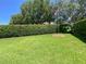 Grassy backyard with hedge and flagpole at 2041 Gold Dust Ct, Trinity, FL 34655