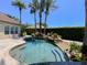 Backyard pool featuring tropical waterfall, beach entry, lush landscaping and large patio area at 2041 Gold Dust Ct, Trinity, FL 34655