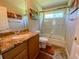 Bathroom featuring granite countertops, a framed mirror, and a shower and bathtub combination behind a glass enclosure at 2041 Gold Dust Ct, Trinity, FL 34655