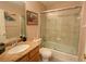Bathroom featuring granite countertops, framed mirror, and a shower and bathtub combination behind a glass enclosure at 2041 Gold Dust Ct, Trinity, FL 34655