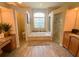 Bright bathroom with a soaking tub under a large window and glass-enclosed shower at 2041 Gold Dust Ct, Trinity, FL 34655
