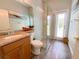 Bathroom with a granite countertop, framed mirror, glass shower, wood-look flooring, and a door to the outside at 2041 Gold Dust Ct, Trinity, FL 34655