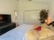 Bedroom with TV, fan, closet, and large bed with decorative pillows, creating a cozy atmosphere at 2041 Gold Dust Ct, Trinity, FL 34655