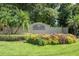 Charming 'Fox Wood' community sign surrounded by colorful flowerbeds and lush greenery at 2041 Gold Dust Ct, Trinity, FL 34655