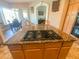 This kitchen island boasts a gas cooktop and granite countertops, providing a modern culinary workspace at 2041 Gold Dust Ct, Trinity, FL 34655