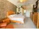 Bright main bedroom with stone wall, ceiling fan, view to ensuite, and natural wood furnishings at 2041 Gold Dust Ct, Trinity, FL 34655