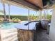 Outdoor kitchen and bar area with a built-in grill, sink, and granite countertops overlooking the pool at 2041 Gold Dust Ct, Trinity, FL 34655
