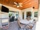 Outdoor covered patio with a ceiling fan, TV, and bar area perfect for relaxing and entertaining at 2041 Gold Dust Ct, Trinity, FL 34655