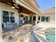 Covered patio with a built-in grill, bar, and retractable awning overlooking the pool and lush landscaping at 2041 Gold Dust Ct, Trinity, FL 34655