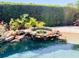 Close-up of the rock waterfall feature flowing into the inviting, refreshing pool at 2041 Gold Dust Ct, Trinity, FL 34655