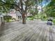 Backyard wooden deck with a tree feature, hammock, grill, and seating area at 22443 Crows Nest Ct, Lutz, FL 33549