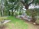 Beautiful backyard featuring a wooden deck with a grill, a fire pit area, and mature trees at 22443 Crows Nest Ct, Lutz, FL 33549