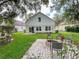 Charming backyard features a fire pit, grassy area, and the home's rear exterior at 22443 Crows Nest Ct, Lutz, FL 33549