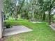 Expansive backyard with a fire pit, lush greenery, and mature trees creating a serene setting at 22443 Crows Nest Ct, Lutz, FL 33549
