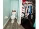 Bathroom with a toilet next to an open closet, featuring tiled floors and painted walls at 22443 Crows Nest Ct, Lutz, FL 33549