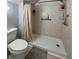 Bathroom with shower and curtain, safety grab bar, shelves, and toilet at 22443 Crows Nest Ct, Lutz, FL 33549