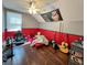 Bedroom featuring hardwood floors, red accent wall, a ceiling fan, window, and a gray accent wall at 22443 Crows Nest Ct, Lutz, FL 33549