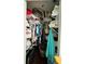 Walk-in closet featuring shelving, clothing, storage bins and a suitcase at 22443 Crows Nest Ct, Lutz, FL 33549