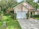 Charming home featuring a white garage door and well-kept landscaping at 22443 Crows Nest Ct, Lutz, FL 33549
