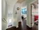Hallway featuring hardwood floors, access to stairs, and a bedroom with a neon 'Open' sign at 22443 Crows Nest Ct, Lutz, FL 33549