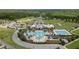 Aerial view of community clubhouse and pool area with lap pool, splash pad, and seating at 22489 Storybook Cabin Way, Land O Lakes, FL 34637