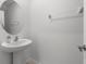 Bright half bathroom features a white pedestal sink, large mirror, and neutral walls at 22489 Storybook Cabin Way, Land O Lakes, FL 34637
