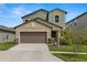 Two story home featuring a two car garage, neutral paint colors, and landscaped yard at 22489 Storybook Cabin Way, Land O Lakes, FL 34637