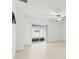 Bright living room featuring tile floors, ceiling fan, and sliding glass door to backyard at 22489 Storybook Cabin Way, Land O Lakes, FL 34637